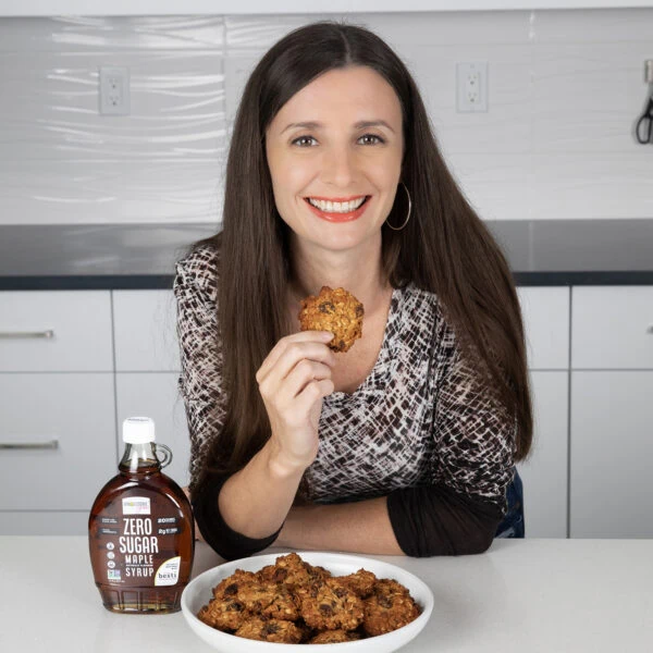 Maya holding a cookie made with Wholesome Yum maple syrup.