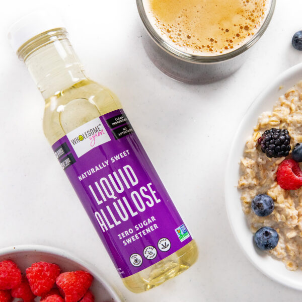 Liquid allulose laying on a countertop next to oatmeal and coffee.