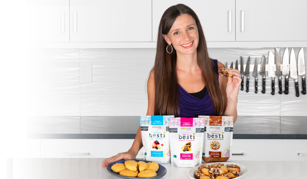 Maya in her kitchen holding a cookie made with Besti products.